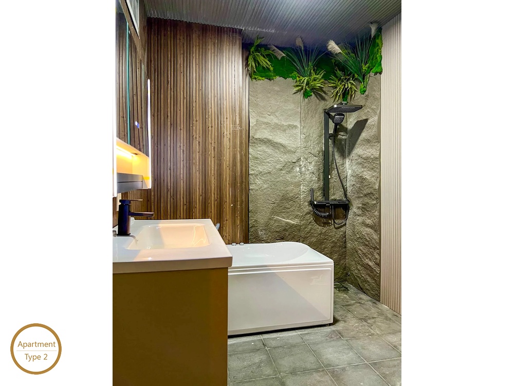 La Rosa 1-Bed modern bathroom with vanity sink bathtub and green plant accent wall