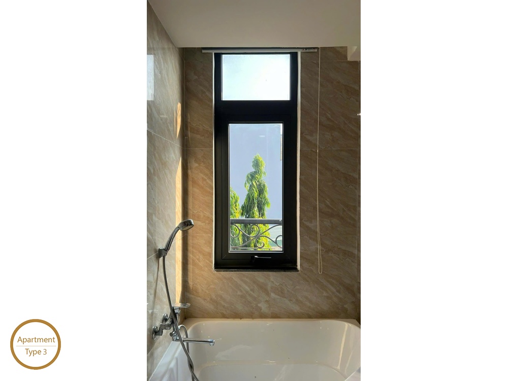 La Rosa 2-Bed soaking bathtub beside window with peaceful treetop view