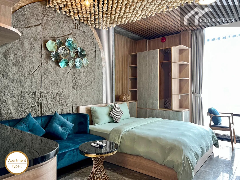 La Rosa Studio comfortable living area with blue couch double bed and wardrobe
