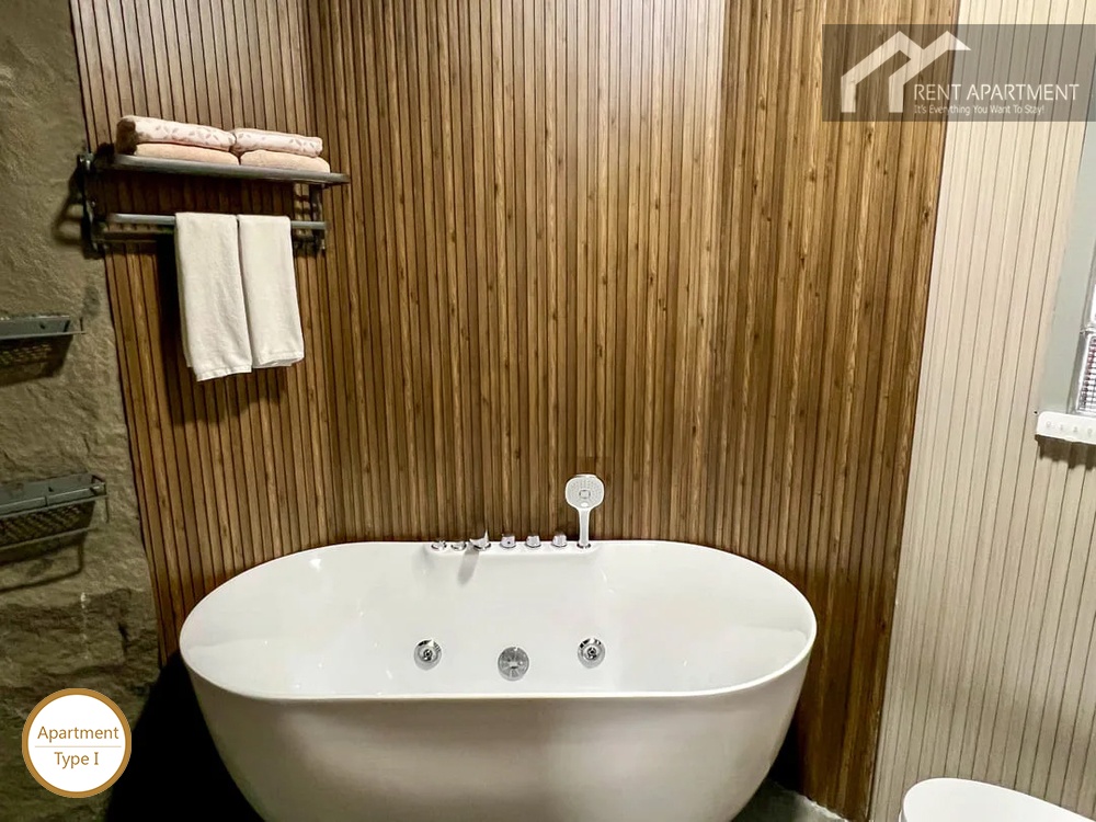 La Rosa Studio full soaking bathtub with chrome fixtures and wood grain accent wall
